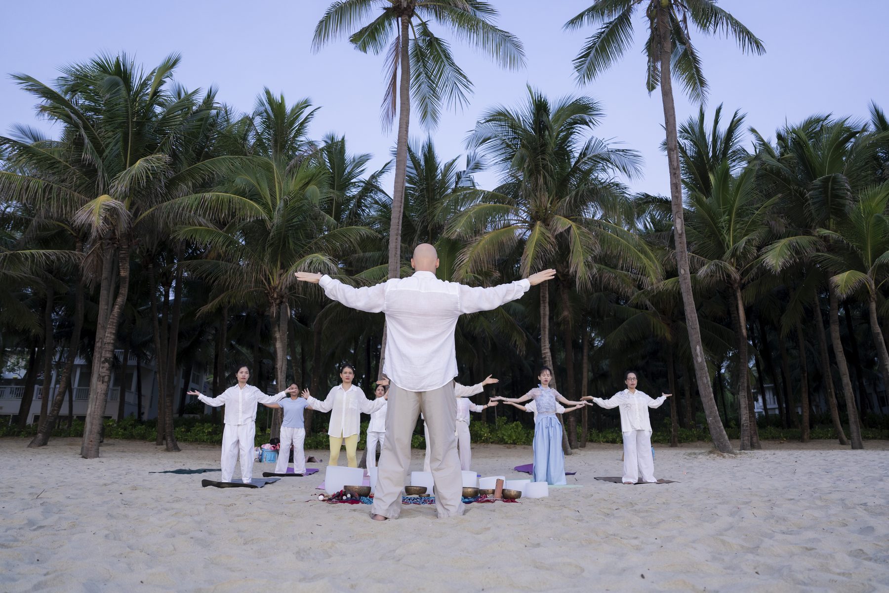 Seb leading a Qigong class among the palms